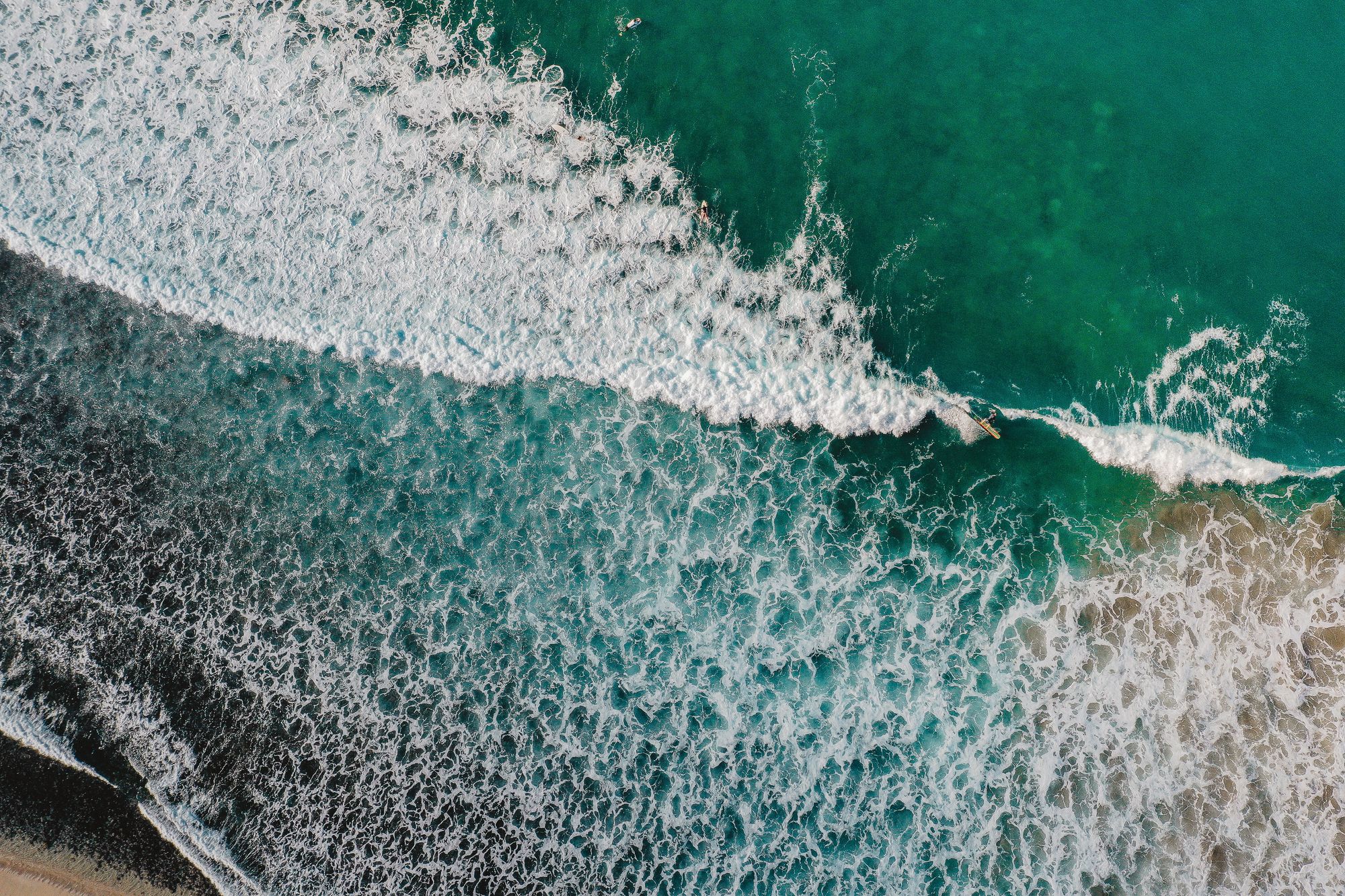 aerial view of a surfer on a wave at Sayulita, one of the best surf towns in Mexico