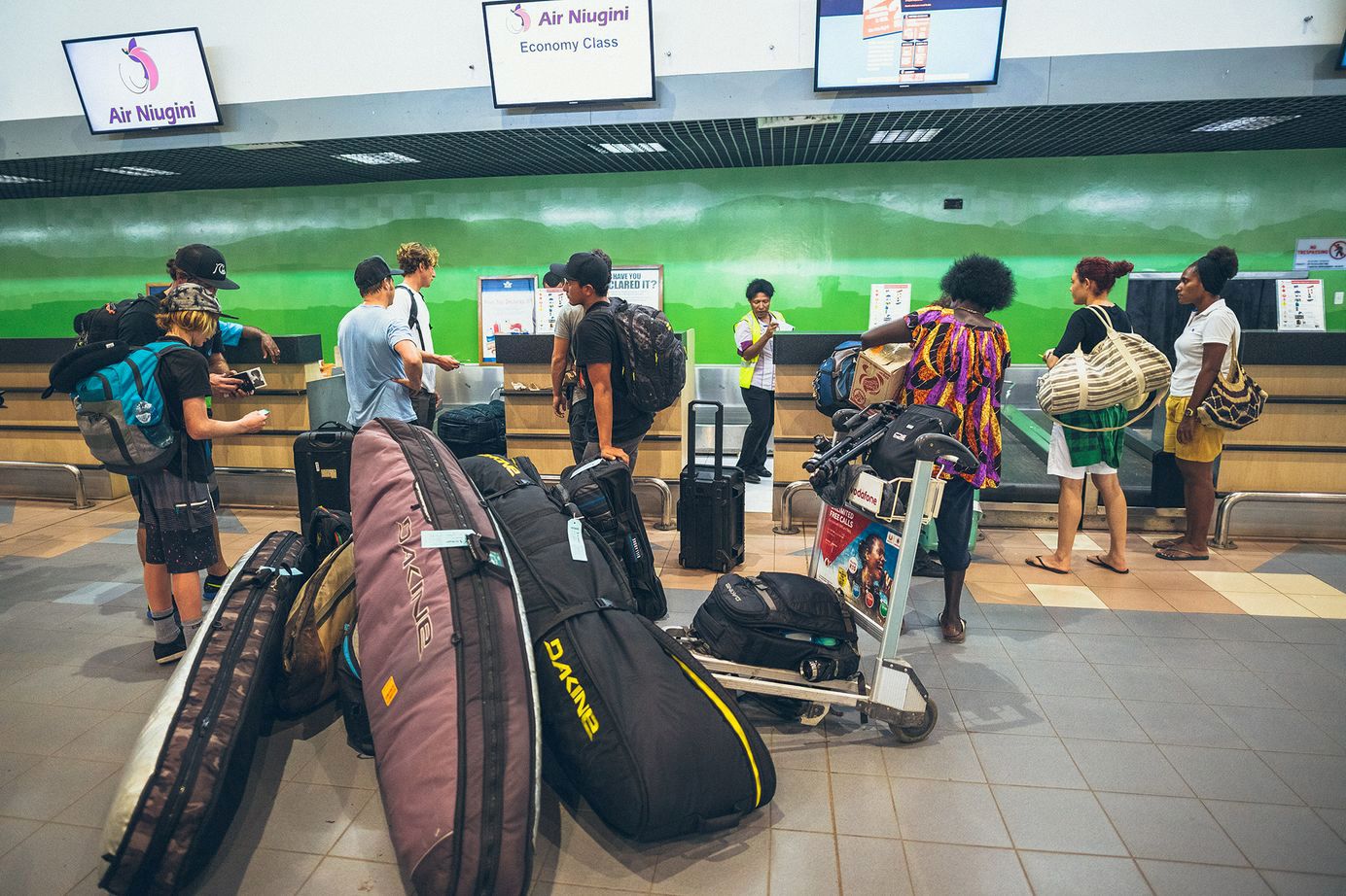 Surfers traveling with surfboards in board bags at the airport